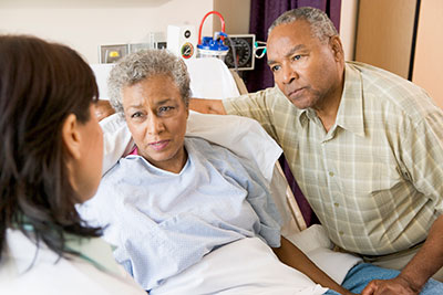 Insurance, Malpractice, Health Insurance A patient and a loved one speaking with a doctor