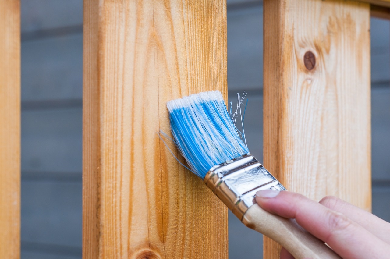 Paint brush painting on wood fence 