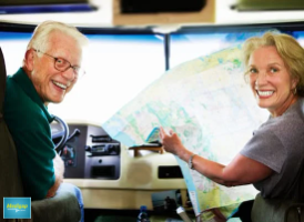 Smiling senior couple in car with map 