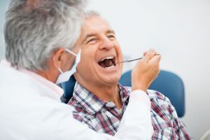 dentist working on older man's teeth